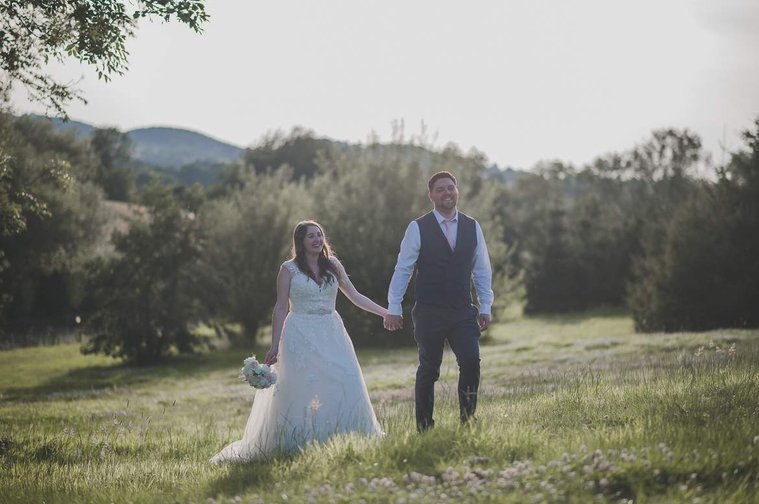 Hannah and KJ stroll in the fields at Skylarks Farm and Wedding Venue, at their wedding in Kettering. By Gary Stafford Photography.