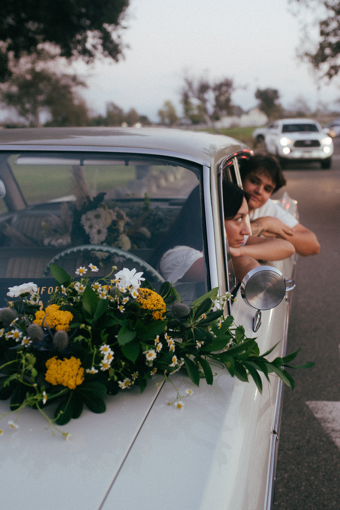 Two young lovebirds pose in their vintage car for their engagement photo session in Fairview Park, Costa Mesa, CA. Vibes are film and romantic. Engagement photography by Aly Rose Photo. California wedding photographer