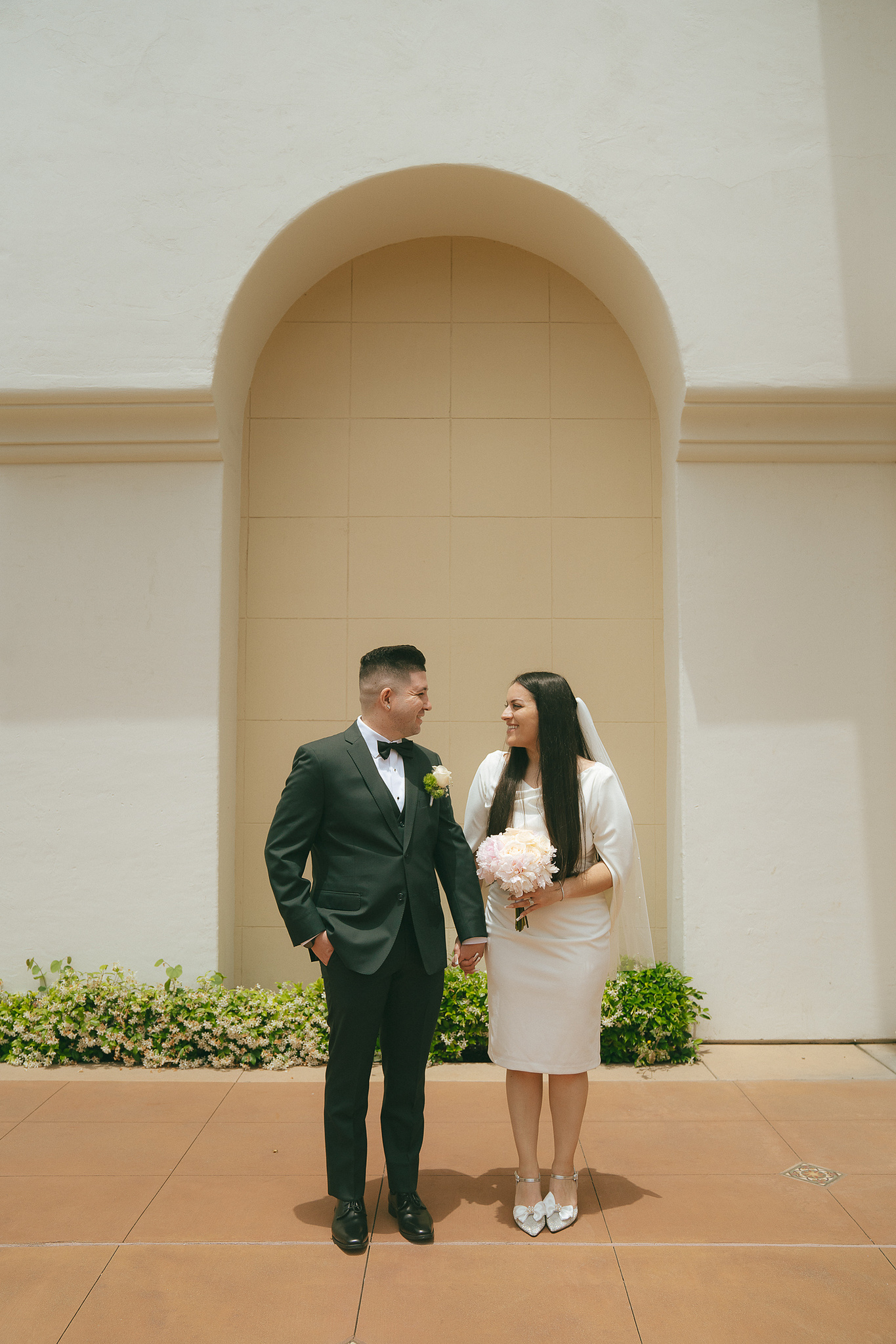 Bride and groom pose, eyes locked on each other, on their summer courthouse wedding day at Laguna Hills Civic Center, Laguna Hills, CA. Film and digital wedding photography by Aly Rose Photo, romantic Southern California elopement photographer.