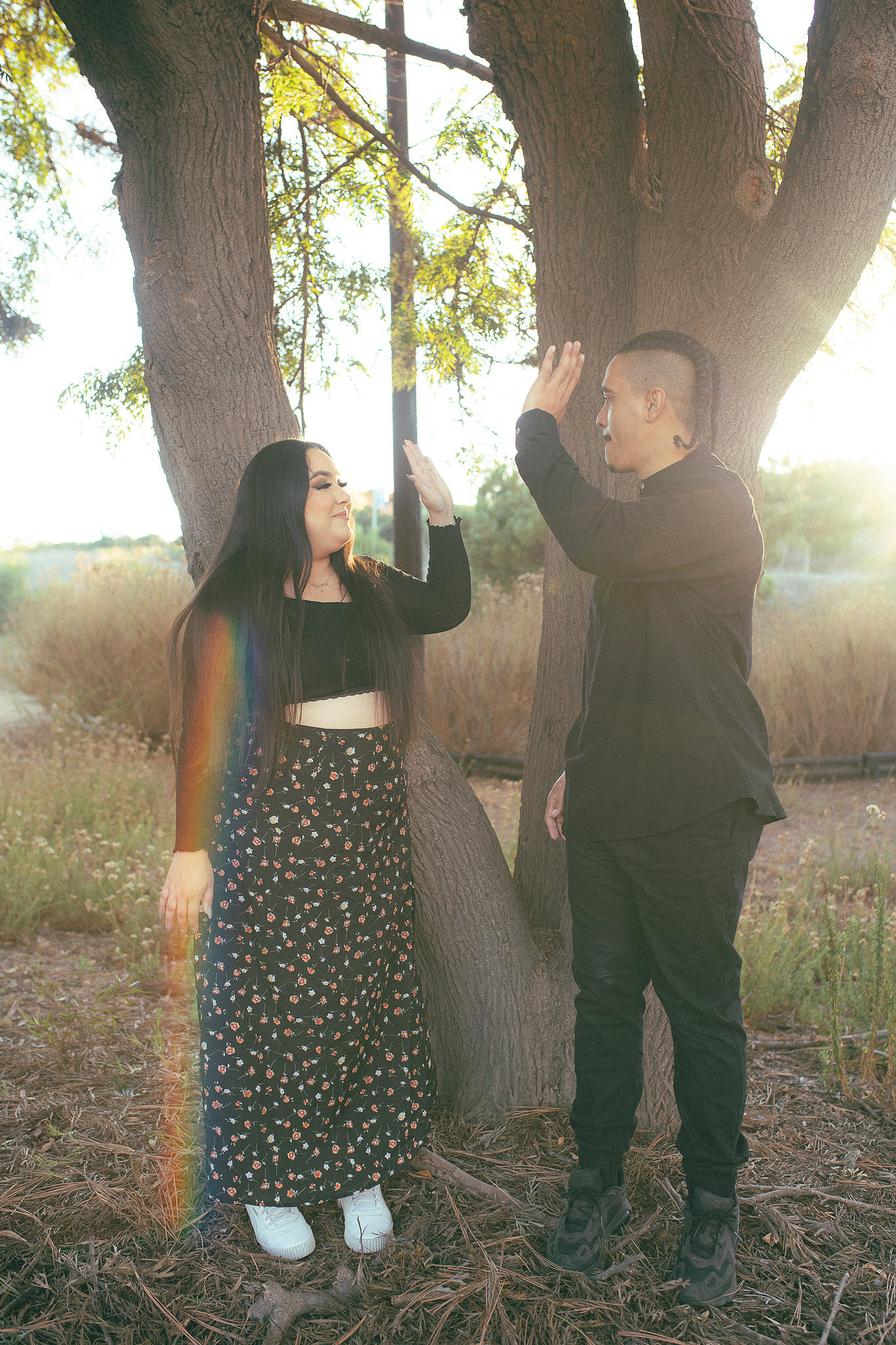 A woman and a man high five in golden, dreamy light in front of a tree. Organic, romantic, dreamy photo by Aly Rose Photo, Southern California portrait photographer. Now booking for Fall Mini Sessions in Orange County. Discount photo packages available