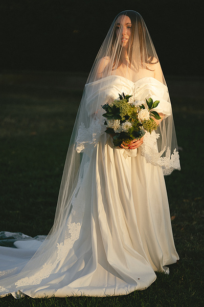Gorgeous, stunning, elegant bridal portraits  in direct sun. The bride poses in her veil with a green floral arrangement. Photography by Aly Rose Photo in Fullerton, CA, Muckenthaler Cultural Center. Wedding, elopement, portrait photographer in SoCal