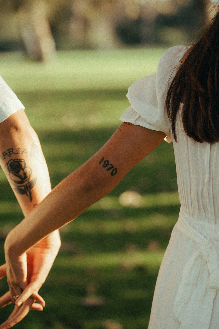 Playful engagement photos in Fairview Park, Costa Mesa, Orange County, CA. Bride and groom hold hands delicately. Photo is closeup of their tattoos. Wedding, elopement, engagement photography by Aly Rose Photo in Southern California