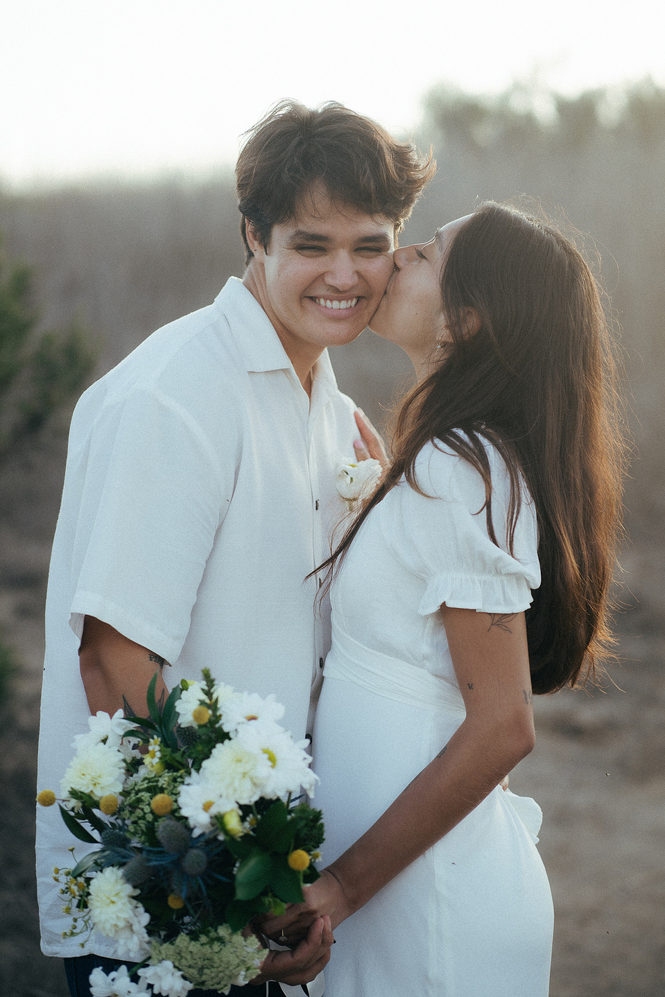 The bride-to-be kisses her groom-to-be on the cheek at their engagement photo session in Fairview Park, Costa Mesa, CA. Natural light engagement photography by Aly Rose Photo. California wedding photographer