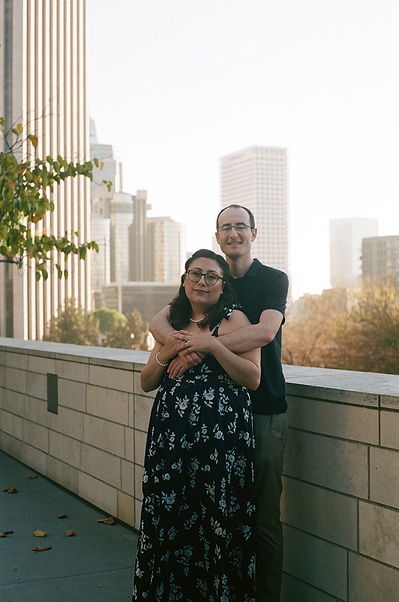 City life engagement shoot in downtown Los Angeles, CA. Engaged couple embrace for a portrait at the Walt Disney Concert Hall. 35mm film. Vibes are cinematic, romantic, organic, authentic. SoCal Wedding elopement photographer Aly Rose Photo