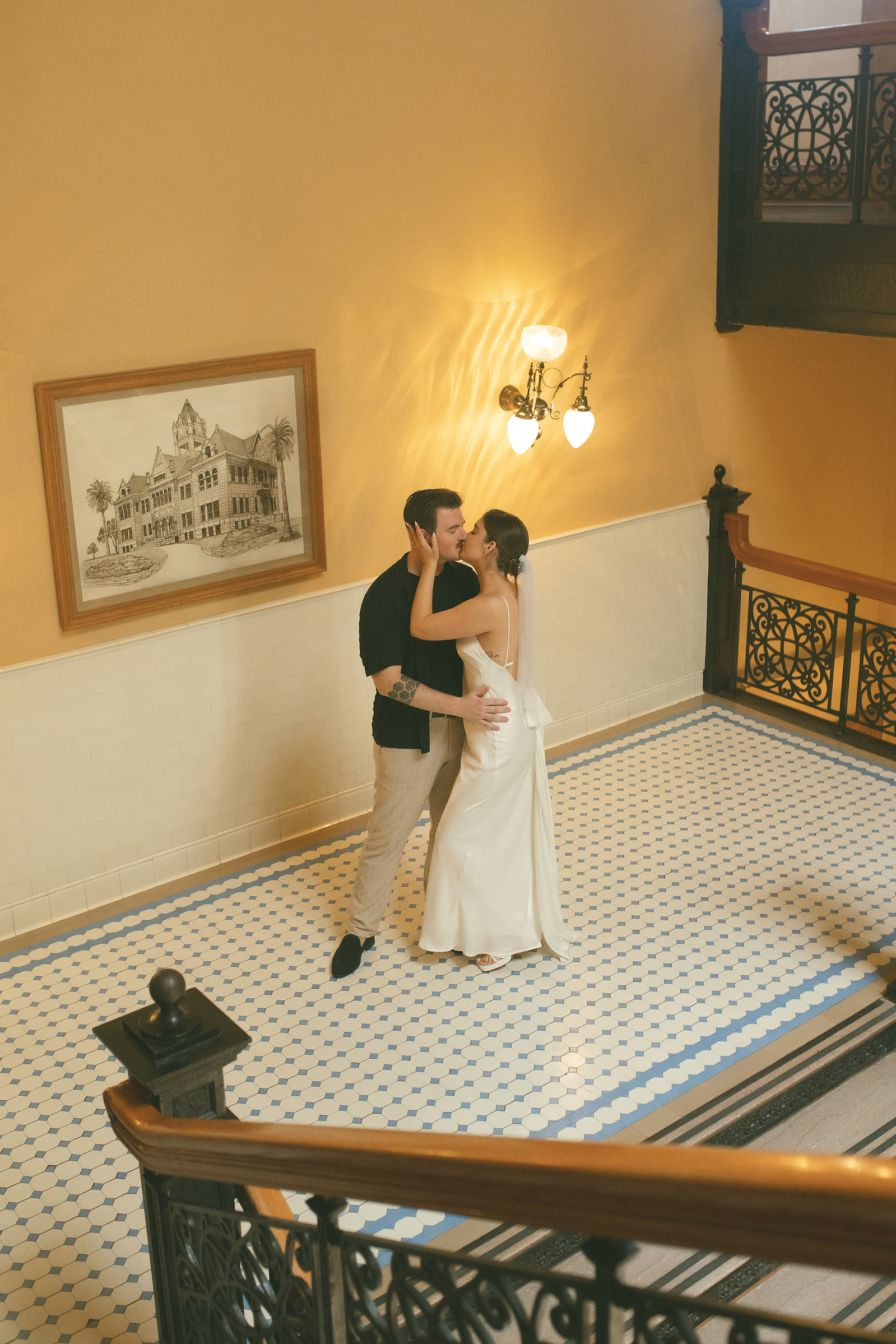 Bride and groom share a kiss and romantic embrace on the central staircase at their courthouse wedding ceremony, Old Orange County Courthouse, Santa Ana, CA, Aly Rose Photo, natural light engagement, elopement, wedding, portrait, lifestyle photographer 