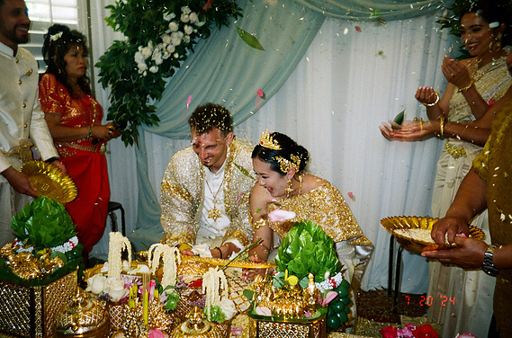 The rice throwing end of a traditional Khmer, Cambodian wedding ceremony. Bride, groom are filled with joy as their friends and family wish them a long and happy marriage. Dreamy, cinematic, organic 35mm film. Long Beach, CA wedding elopement photographer