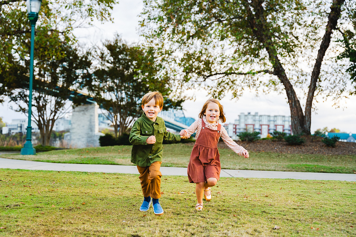 Candid family moment in the wide green spaces of Coolidge Park, perfect for outdoor portraits.