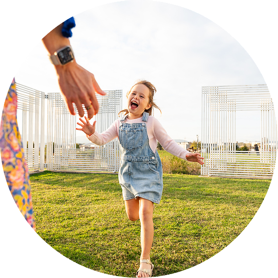 Candid family moment at Montague Sculpture Field, with children playing in lush green surroundings