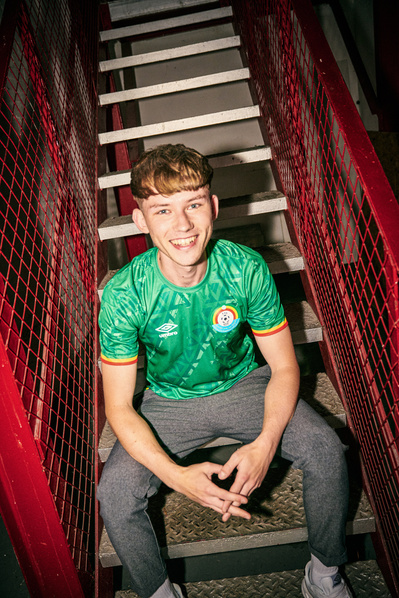 lad-smiling-stairs-Umbro-Ethiopia-shirt-shot-by-matthew-stansfield