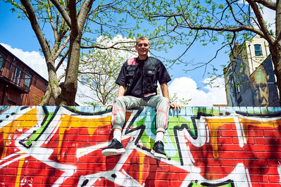 lad-sat-wall-graffiti-smiling-shot-by-matthew-stansfield