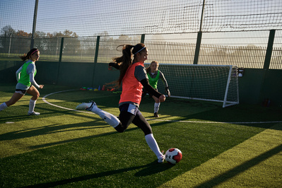 under-armour-girl-kicking-football-pitch-photo-by-matthew-stansfield