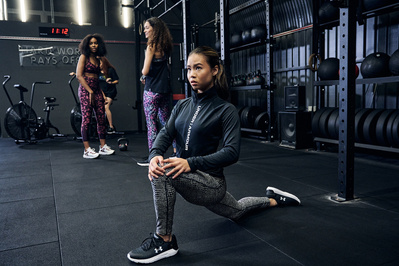 portrait of athlete in gym training stretching lunging to warm up shot for under armour photography by matthew stansfield