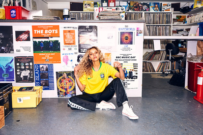 girl-wearing-football-shirt-sat-record-shop-shot-by-matthew-stansfield