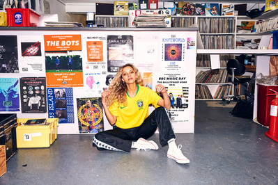 girl-wearing-football-shirt-sat-record-shop-shot-by-matthew-stansfield