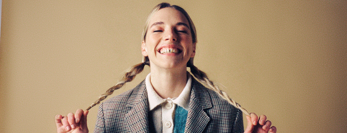 portrait-girl-sitting-laughing-plaits-film-studio-photography-by-matthew-stansfield