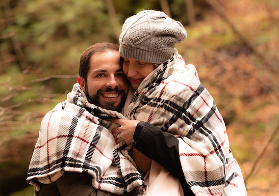 Wedding Photographer-Uniquely Created Photography. Bride and groom after the wedding hugging outside in the cold.