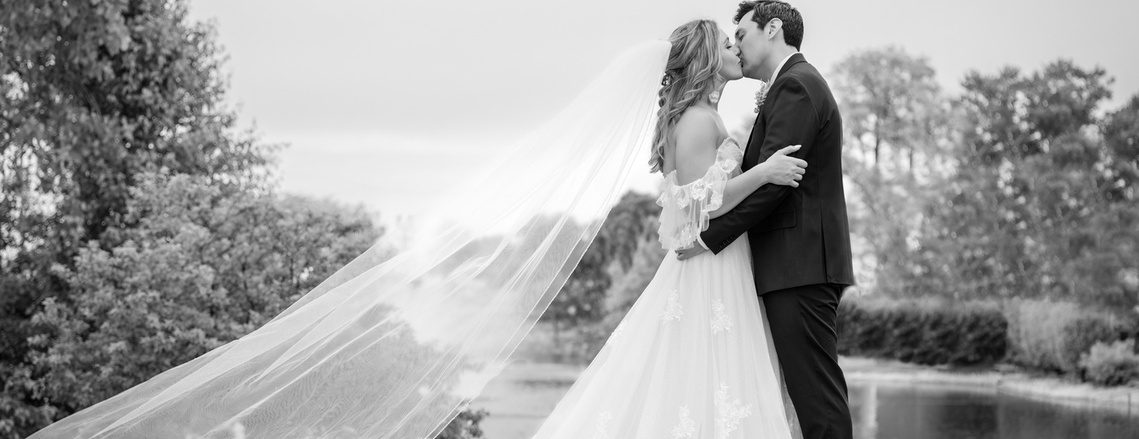 Wedding Photographer-Uniquely Created Photography. Bride and groom after the wedding long veil