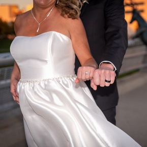 bride and groom showing off wedding rings
