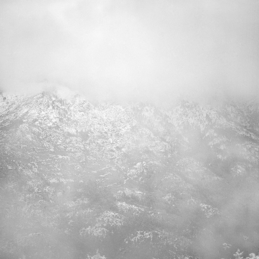 Black and white view of a mountain in cloud and snow