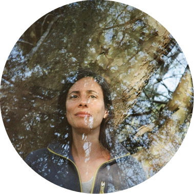 Double exposure photograph of Rebecca Marshall, with trees and sky superimposed