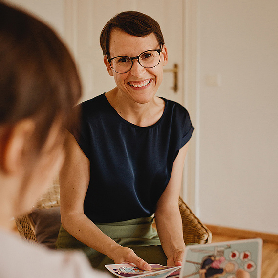Ein ungestelltes Businessfoto zeigt eine Therapeutin im Gespräch mit einer jungen Patientin. 