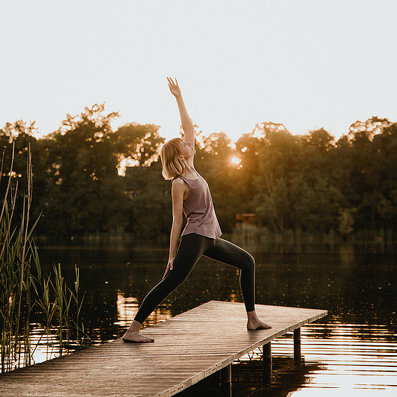 Für natürliche Personal Branding Fotos in Berlin macht eine Yogalehrerin auf einem Steg eine Yogaübung. 
