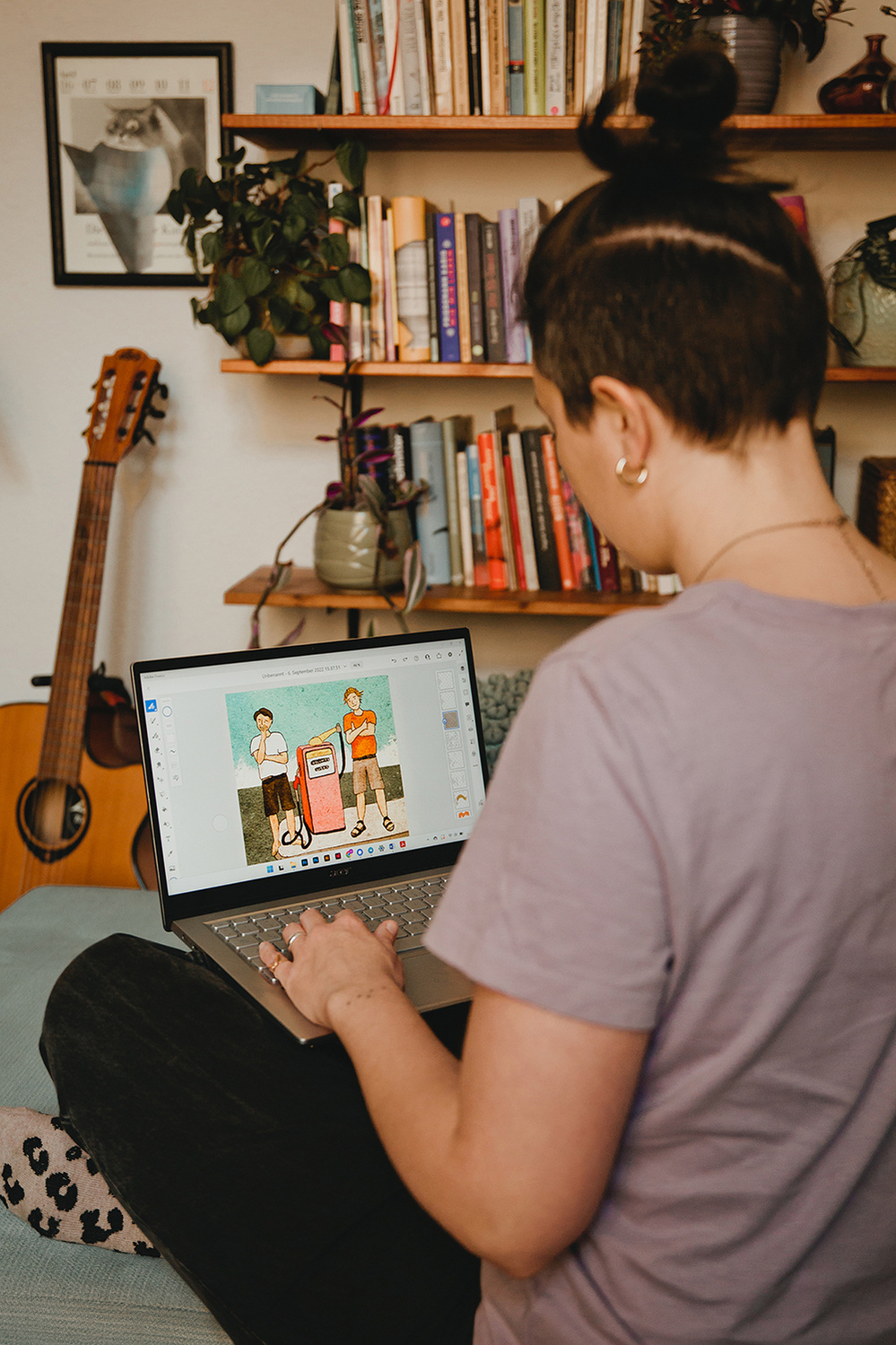 Eine Grafikdesignerin sitzt beim Personal Branding Fotoshooting in Berlin an ihrem Laptop und gestaltet eine Illustration.