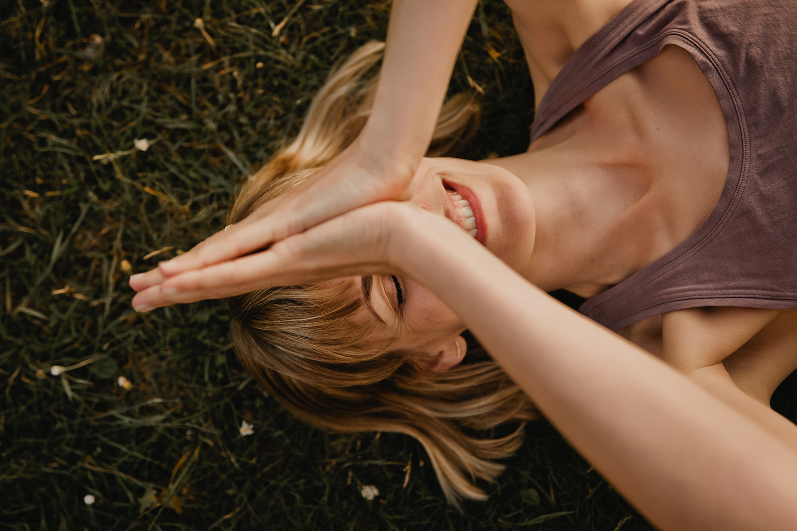 Beim Business Fotoshooting in Berlin liegt eine Yogalehrerin lachend auf einer Wiese.