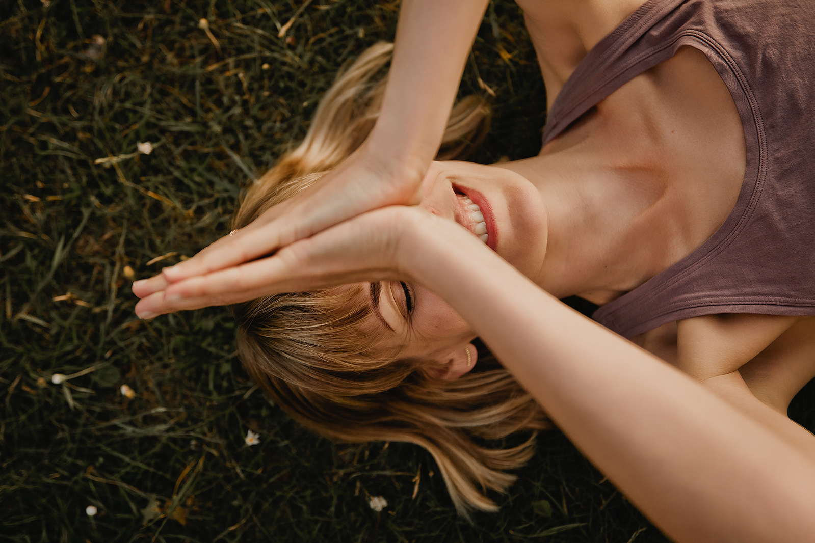 Beim Business Fotoshooting in Berlin liegt eine Yogalehrerin lachend auf einer Wiese.