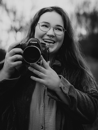 Ungestelles Businessportrait einer Corporate Fotografin aus Berlin mit ihrer Kamera.