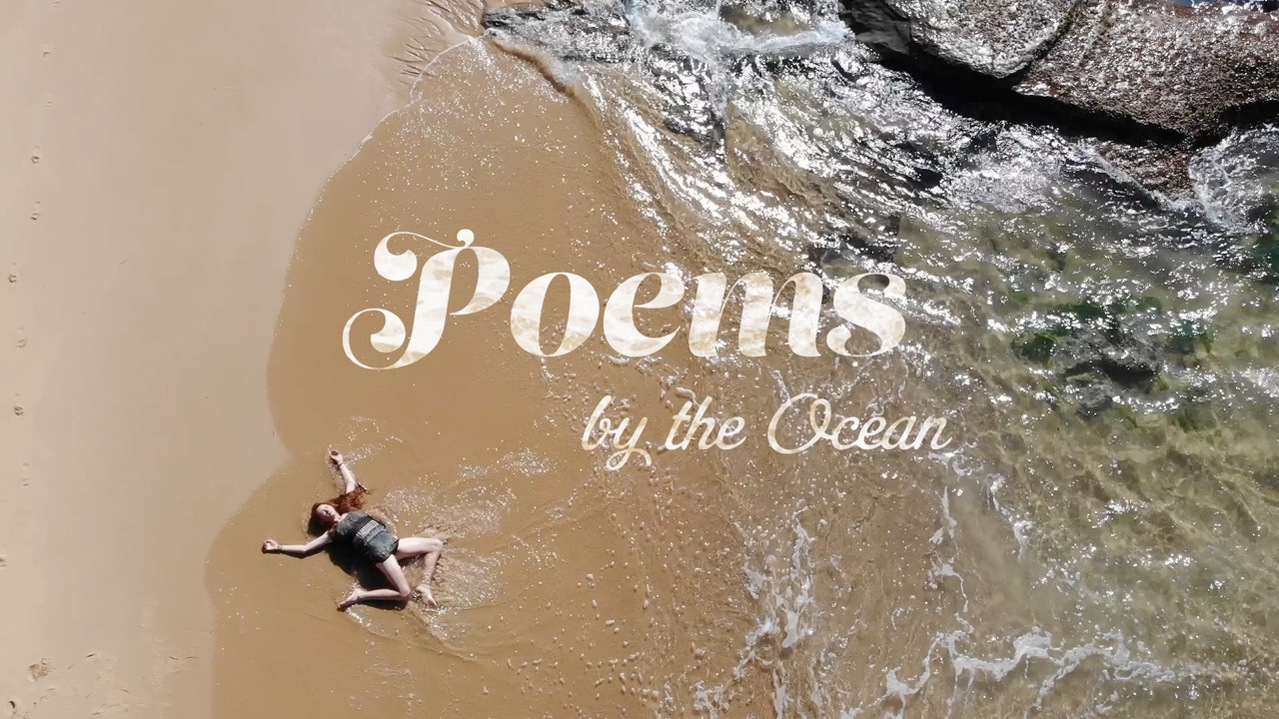 Jacinta Rose Durney lies on a gorgeous beach with waves all around her. This is the title shot for the short film "Poems by the Ocean."
