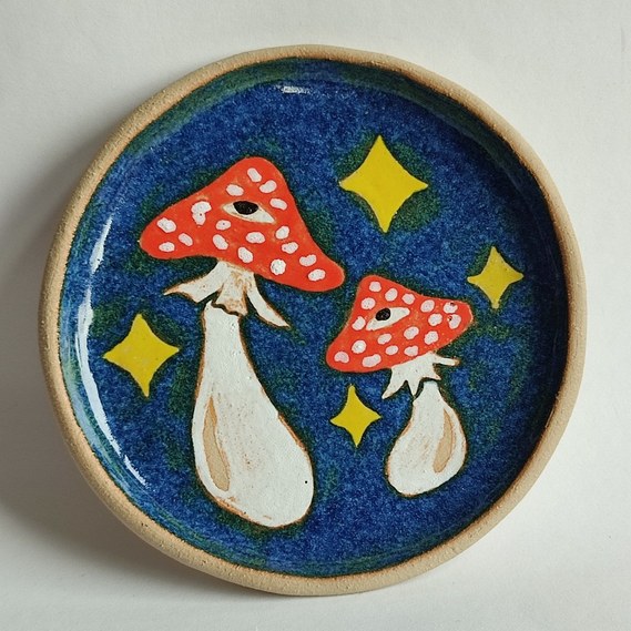 one blue handmade ceramic plate with mushrooms painted on it.
