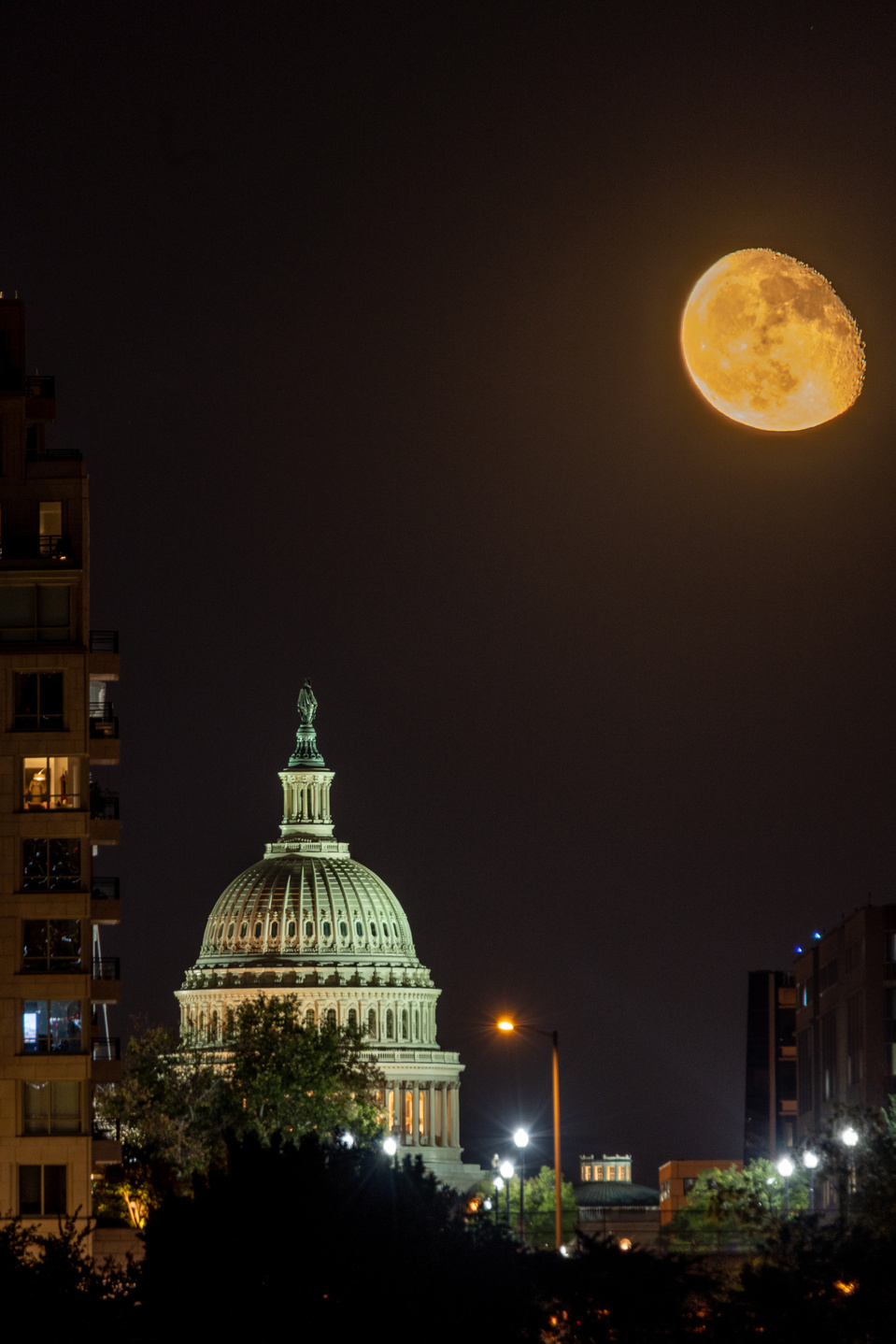 Three-quarters moon rising over U.S. Capitol