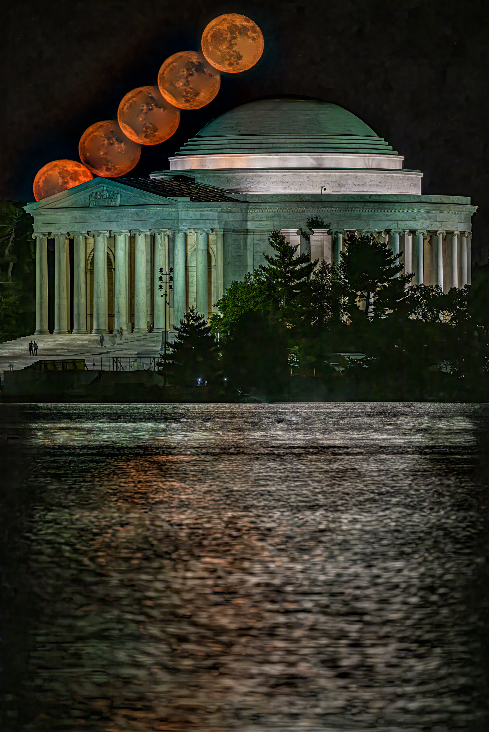 Timelapse image showing Orange-colored  full moon arcing over Jefferson Memorial, Washington DC, moonrise