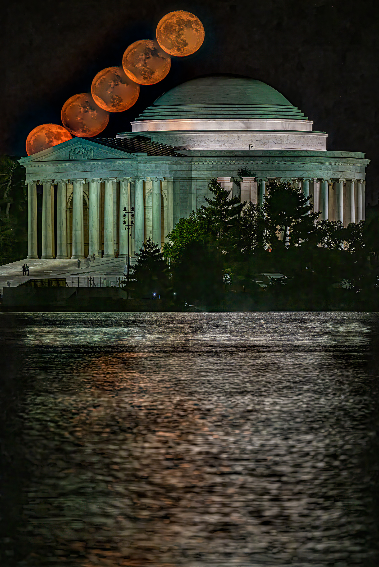 Timelapse image showing Orange-colored  full moon arcing over Jefferson Memorial, Washington DC, moonrise