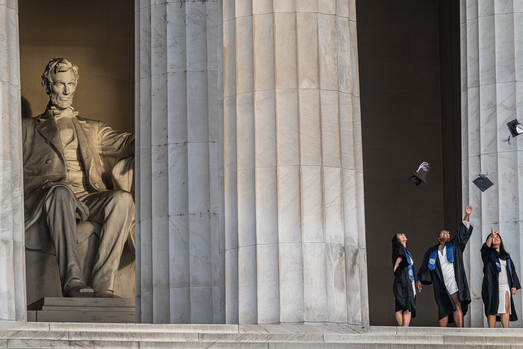 Lincoln in his Memorial watches the graduates tossing their caps into the air