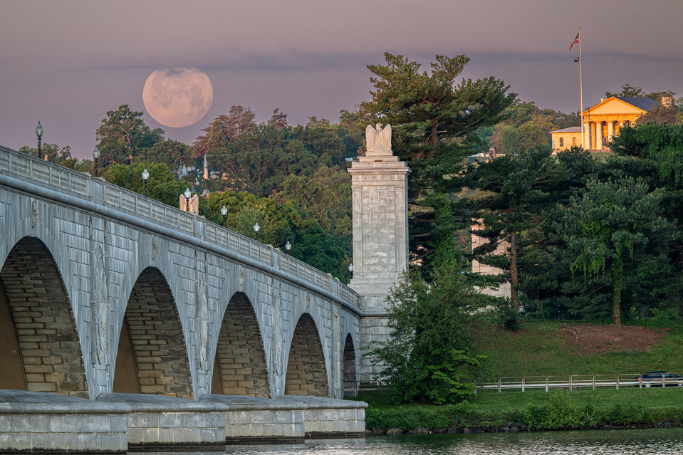 Full moon setting behind Memorial Bridge and Arlington Lee House in background