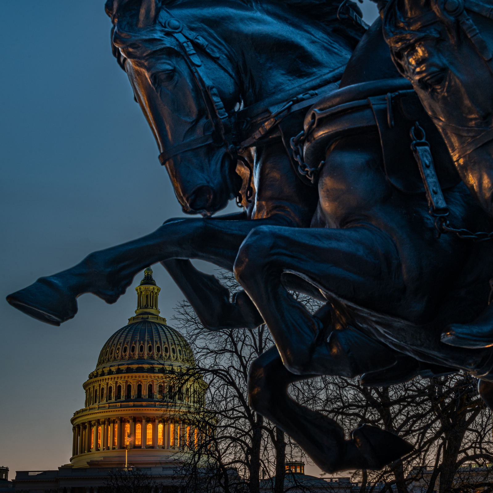 U. S. Capitol dome lit from within, framed by horse hooves at the Ulysses Grant memorial on west side of Capitol