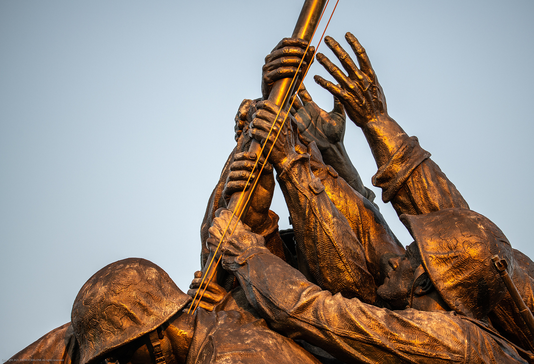 Closeup of hands of the soldiers grasping flagpole, United States Marine Corps Memorial statue in Arlington Virginia  showing Iwo Jima flag raising 