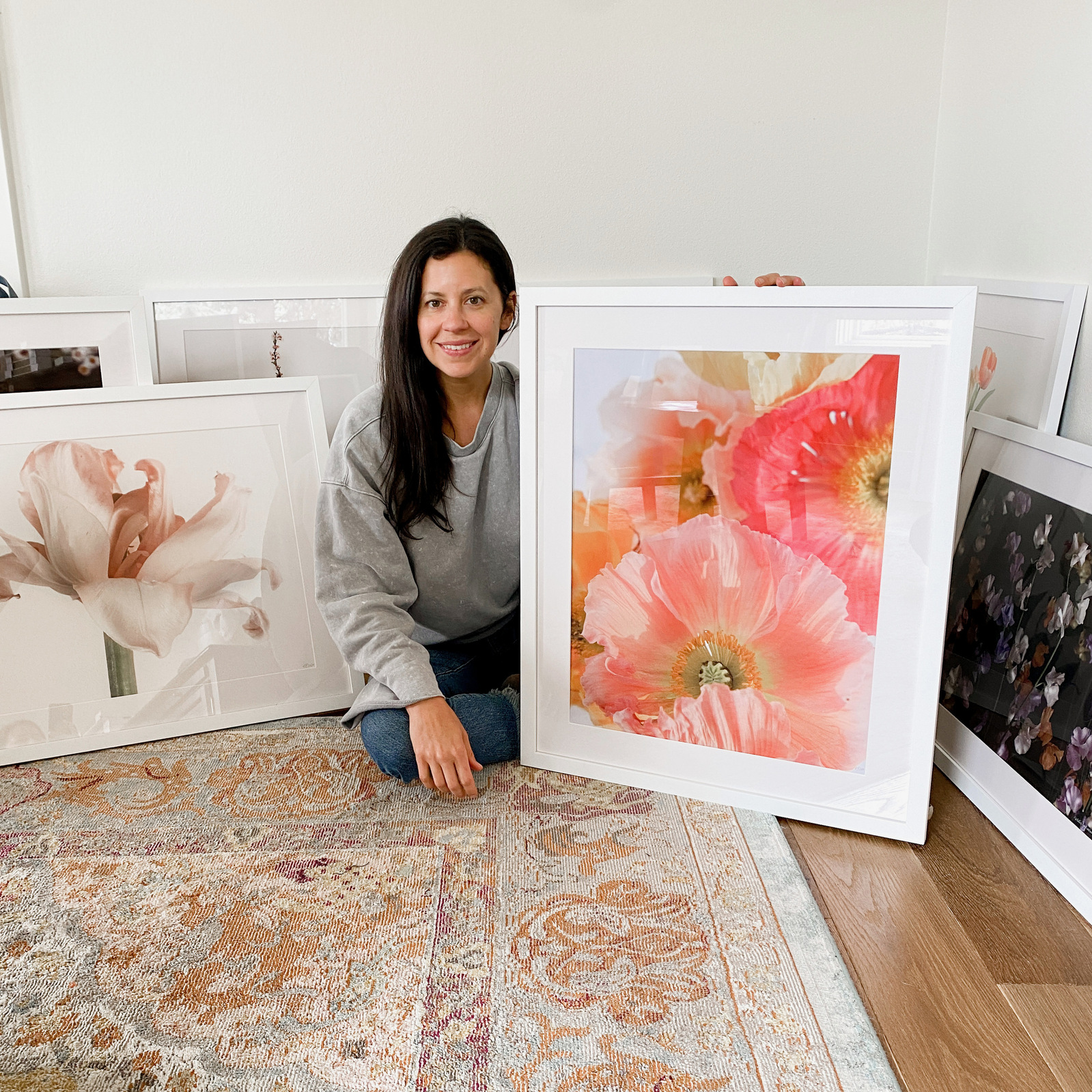 Natalie Pigliacampo portrait with framed floral artwork. 