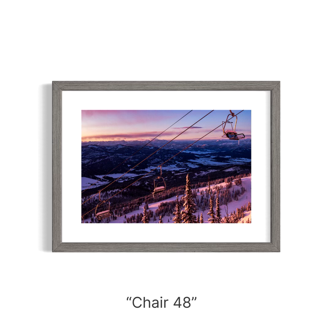 A ski area chair lift sits at a standstill as the early morning light shines on the snow.