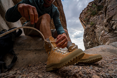 A person tying their hiking boot in the west Texas desert. Authentic commercial stock photography.