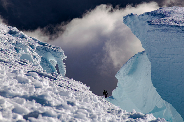 An unknown climber ascending towards the summit of Mt Rainier in Wasington State via the Disspaointment Cleaver route. A marin layer of clouds engulf the valley floors below.