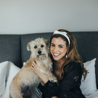 Bride smiling with her dog getting ready on her wedding day.
