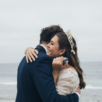 Romantic wedding photography of a moment captured of a bride and groom exchanging rings in Malibu, CA.