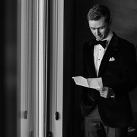 Black and white groom getting ready prepping his vows.