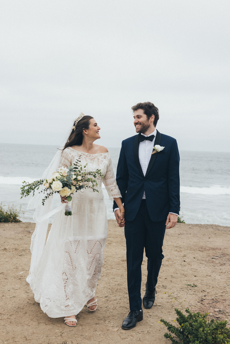 Romantic wedding photography of a bride and groom walking on the beach in Malibu, CA.