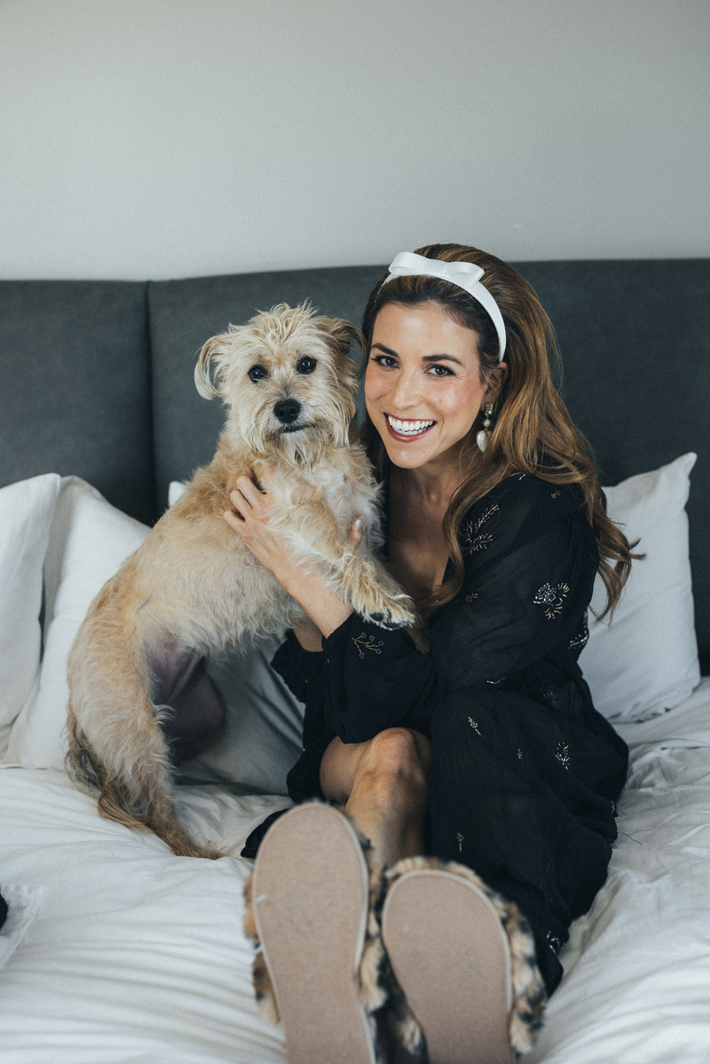 Bride smiling with her dog getting ready on her wedding day.