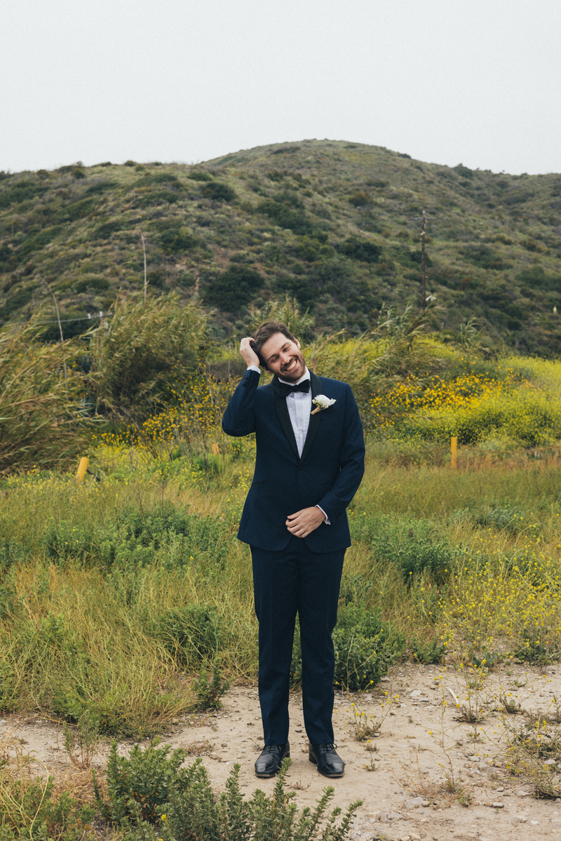 Wedding photography of groom waiting for bride on an overcast wedding day in Malibu, California.