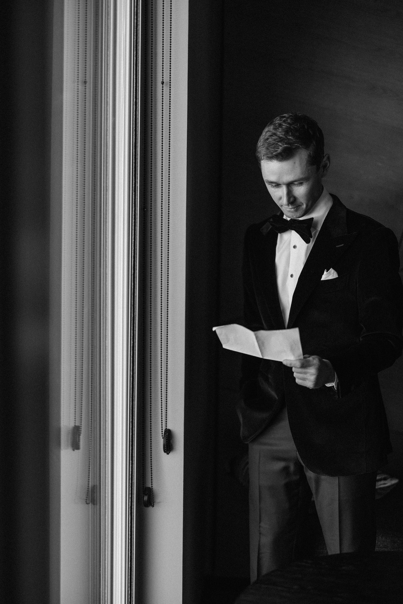 Black and white groom getting ready prepping his vows.